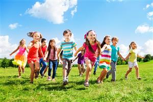 Group of young children, colorfully attired, running in a field